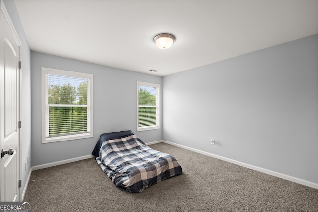 carpeted bedroom featuring visible vents and baseboards
