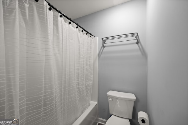 bathroom featuring shower / bath combo and toilet