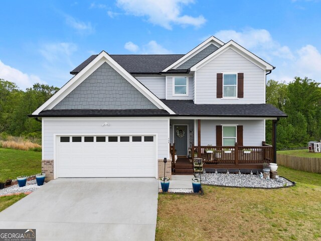 craftsman inspired home with a garage, a porch, driveway, and a front yard