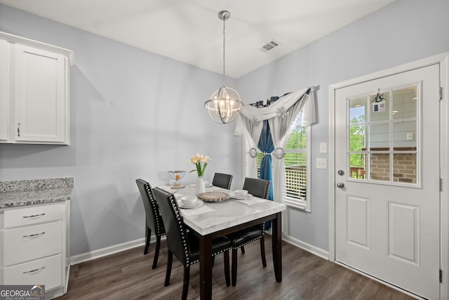 dining space with visible vents, dark wood-style flooring, a chandelier, and baseboards