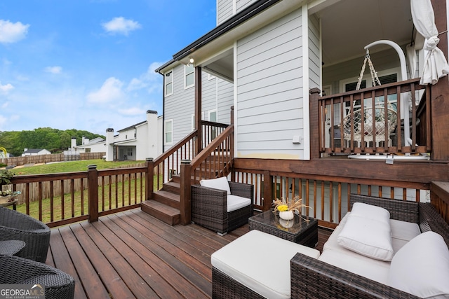 wooden deck with an outdoor living space and fence