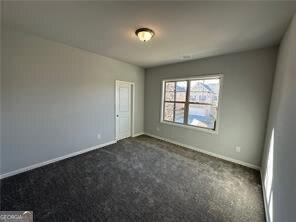 3421 Andover Way, Buford, GA 30519 - spare room with baseboards and dark carpet