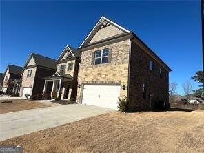 3421 Andover Way, Buford, GA 30519 - view of front of home with a garage, driveway, and stone siding
