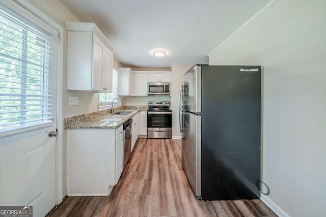 4442 Mercer Rd, Decatur, GA 30035 - kitchen with white cabinetry, stainless steel appliances, light wood-type flooring, and a sink