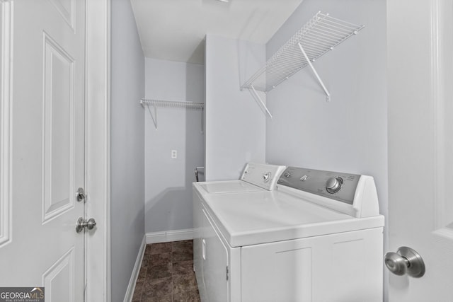 clothes washing area with laundry area, baseboards, and washing machine and clothes dryer