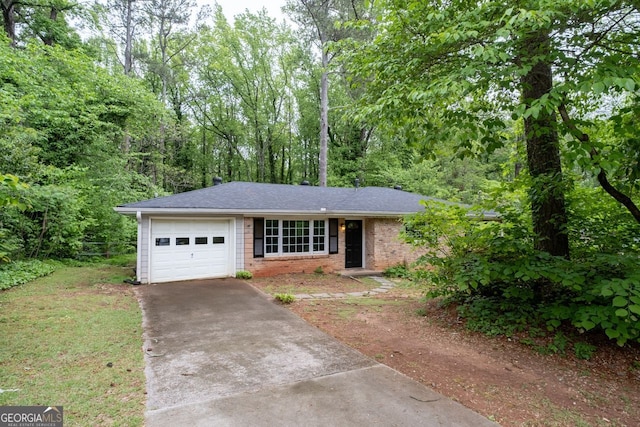 single story home featuring a garage, a shingled roof, concrete driveway, and brick siding
