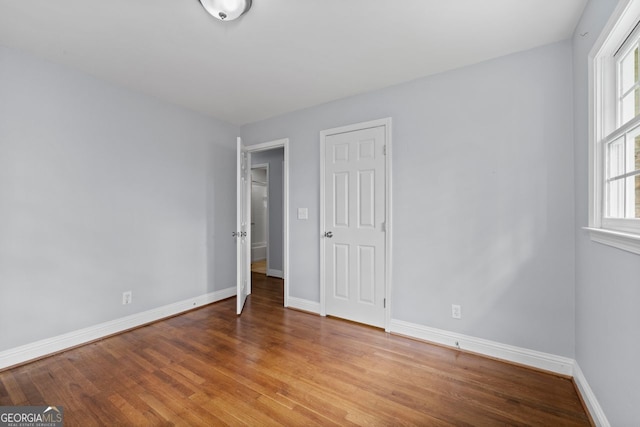unfurnished bedroom featuring baseboards and wood finished floors