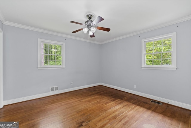 spare room featuring baseboards, ceiling fan, wood-type flooring, and visible vents