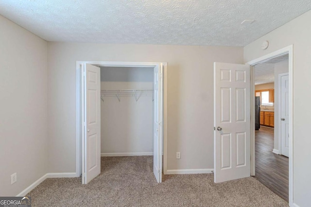 8051 Trinity Park Dr, Riverdale, GA 30296 - unfurnished bedroom with freestanding refrigerator, carpet flooring, a closet, and a textured ceiling