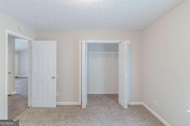 8051 Trinity Park Dr, Riverdale, GA 30296 - unfurnished bedroom featuring a textured ceiling, carpet floors, a closet, and baseboards