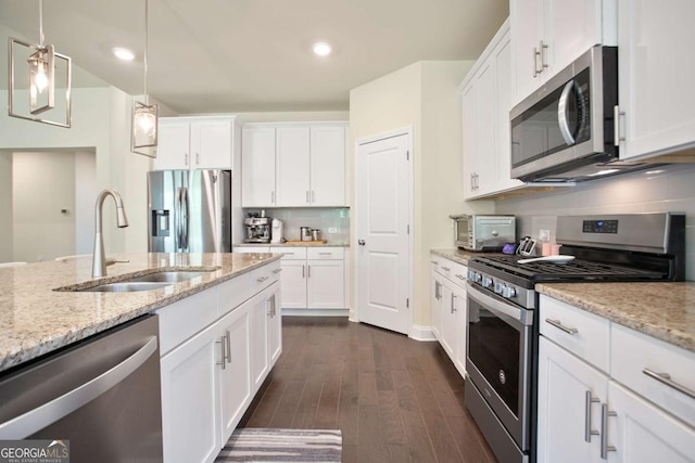 kitchen featuring backsplash, a sink, white cabinetry, and stainless steel appliances