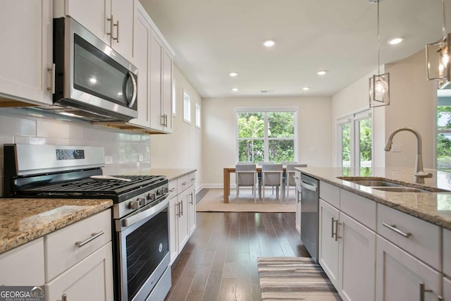 kitchen with a sink, white cabinets, and stainless steel appliances