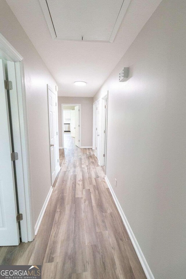 hallway with light wood finished floors and baseboards