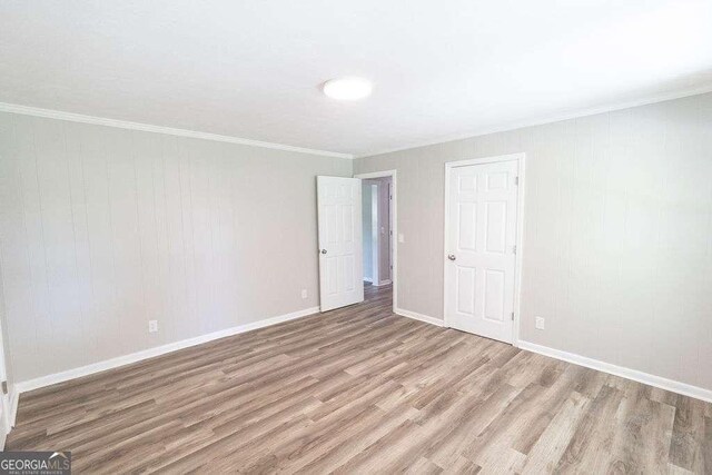 interior space featuring crown molding, wood finished floors, and baseboards