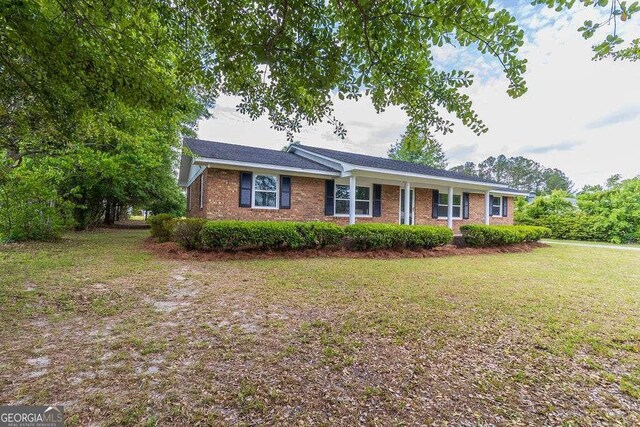 single story home featuring a front yard and brick siding