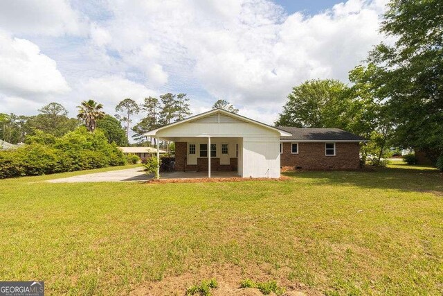 back of property with brick siding and a yard