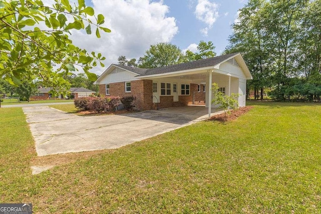 back of house featuring driveway, a yard, an attached carport, and brick siding