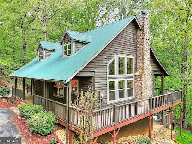 455 Old Cherokee Rd, Cleveland, GA 30528 - back of property with metal roof, a wooded view, log veneer siding, and a chimney