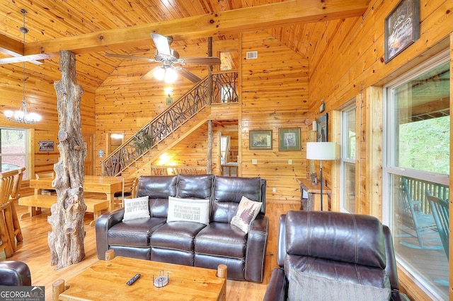 455 Old Cherokee Rd, Cleveland, GA 30528 - living area featuring beamed ceiling, wood walls, stairs, wood finished floors, and ceiling fan with notable chandelier