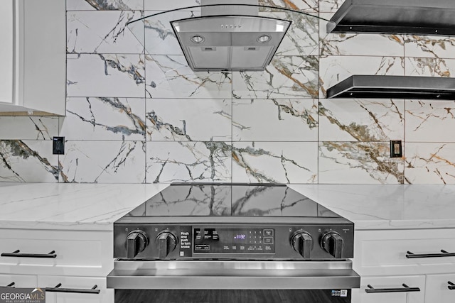 details featuring white cabinetry, light stone countertops, and electric range