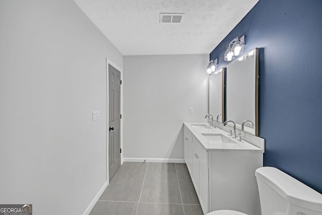 bathroom featuring toilet, a textured ceiling, visible vents, and a sink