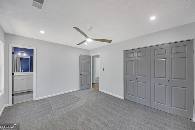 unfurnished bedroom featuring carpet floors, baseboards, visible vents, and a sink