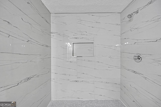 full bath with a textured ceiling and a marble finish shower