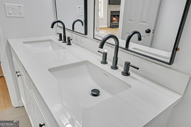 details with a tiled fireplace and vanity