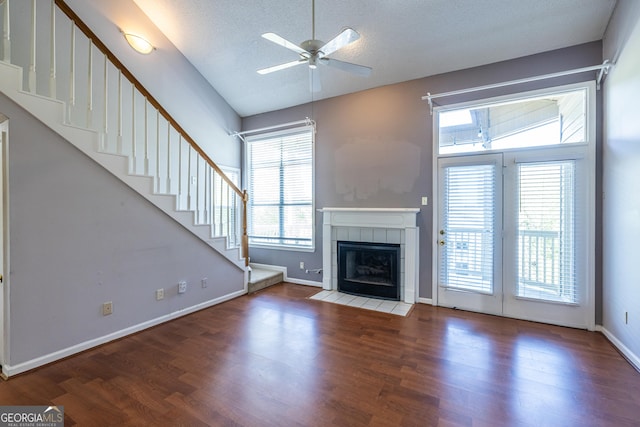 unfurnished living room with ceiling fan, plenty of natural light, and wood finished floors