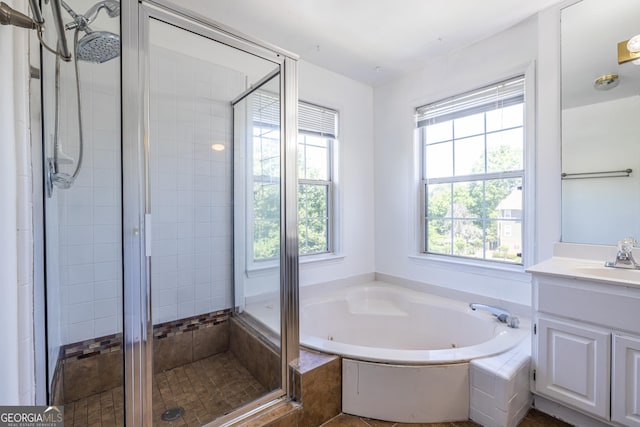 bathroom with vanity, a shower stall, and a tub with jets