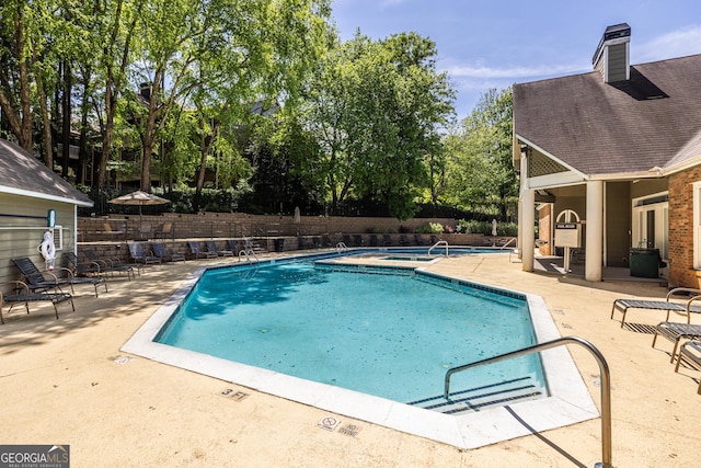 pool featuring fence and a patio area