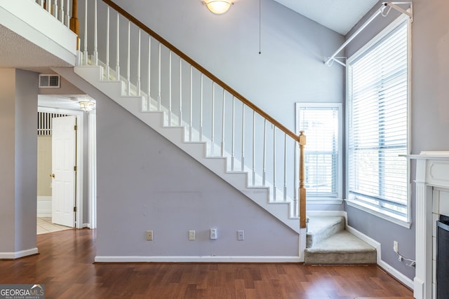 stairs with visible vents, wood finished floors, and a healthy amount of sunlight