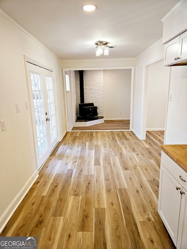 802 Colquitt Cir, Albany, GA 31707 - unfurnished dining area featuring baseboards, a wood stove, ornamental molding, and light wood-type flooring