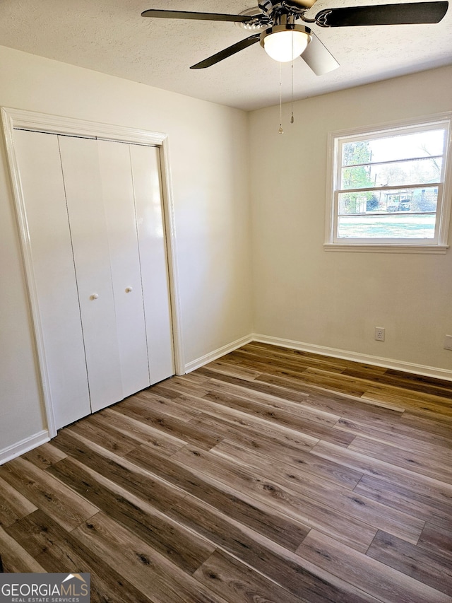 802 Colquitt Cir, Albany, GA 31707 - unfurnished bedroom with dark wood-type flooring, ceiling fan, baseboards, and a closet