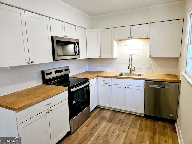 802 Colquitt Cir, Albany, GA 31707 - kitchen with a sink, butcher block countertops, ornamental molding, and stainless steel appliances