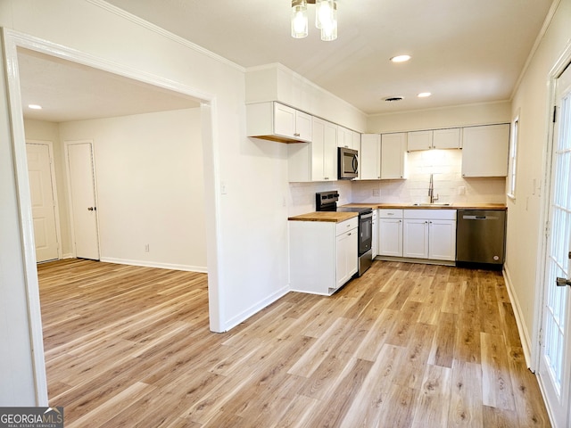 802 Colquitt Cir, Albany, GA 31707 - kitchen with light wood-style flooring, butcher block counters, appliances with stainless steel finishes, backsplash, and a sink