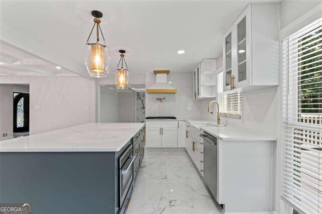 2023 Stoneleigh Dr, Stone Mountain, GA 30087 - kitchen with stainless steel dishwasher, a sink, oven, custom exhaust hood, and marble finish floor