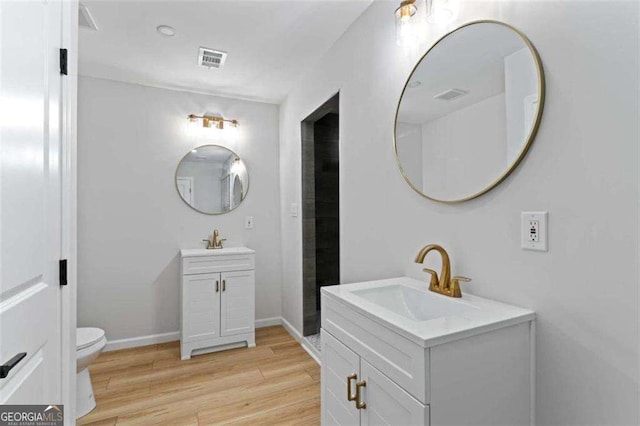 2023 Stoneleigh Dr, Stone Mountain, GA 30087 - bathroom with wood finished floors, visible vents, two vanities, and a sink