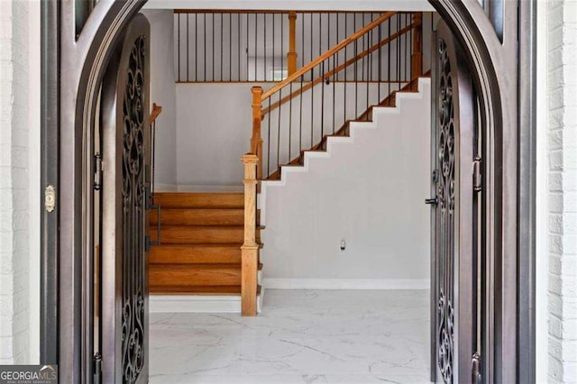 2023 Stoneleigh Dr, Stone Mountain, GA 30087 - stairs featuring baseboards, marble finish floor, and arched walkways