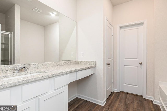 267 Oliver Dr, Locust Grove, GA 30248 - bathroom with vanity, a stall shower, visible vents, baseboards, and wood finished floors