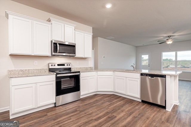 267 Oliver Dr, Locust Grove, GA 30248 - kitchen with dark wood finished floors, appliances with stainless steel finishes, white cabinets, ceiling fan, and a peninsula