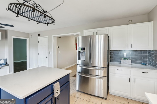 3979 Doral Cir, Atlanta, GA 30360 - kitchen featuring stainless steel fridge, blue cabinets, white cabinets, and light tile patterned floors
