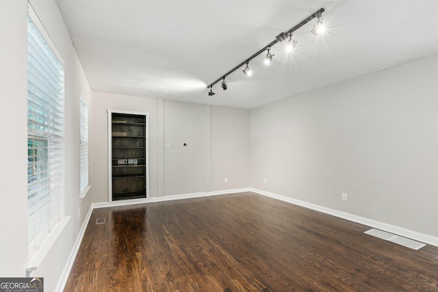 3979 Doral Cir, Atlanta, GA 30360 - unfurnished room with rail lighting, dark wood finished floors, baseboards, and built in features