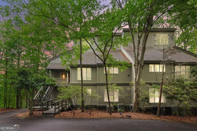 view of front of house featuring stairway and roof with shingles