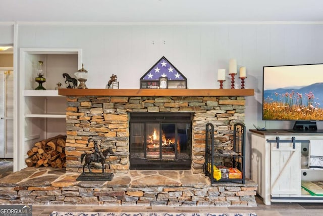 details with crown molding, a stone fireplace, and built in features