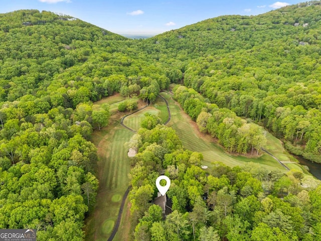 birds eye view of property with a mountain view, golf course view, and a view of trees