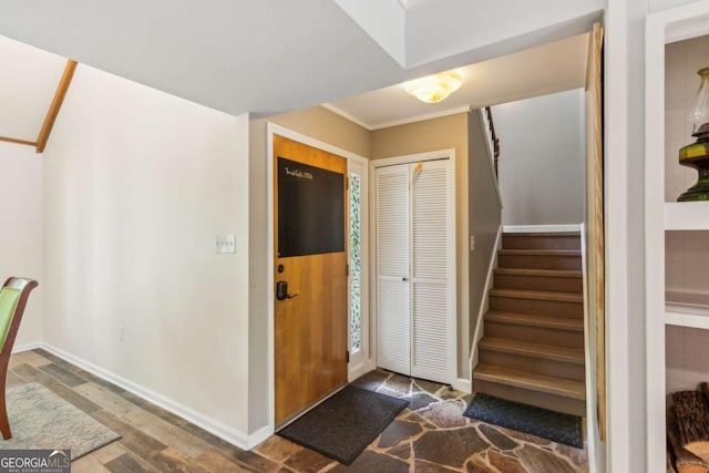foyer with stairs, wood finished floors, and baseboards