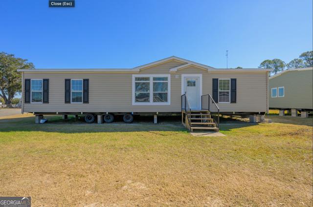 manufactured / mobile home featuring a front lawn