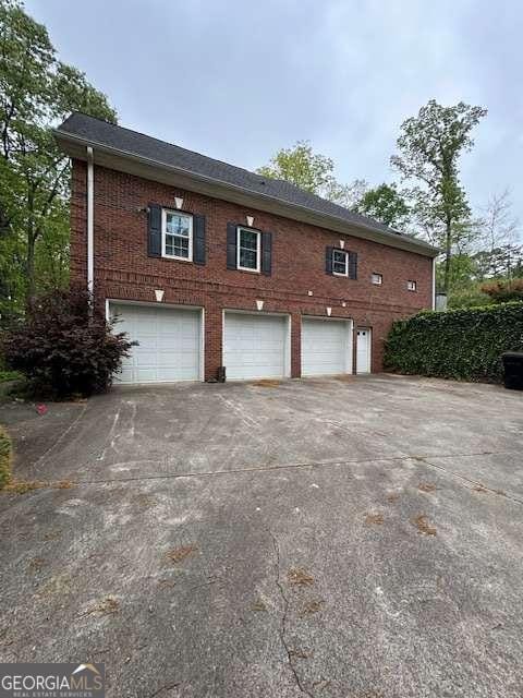 8010 Scudder Way, Ball Ground, GA 30107 - view of home's exterior with an attached garage, concrete driveway, and brick siding
