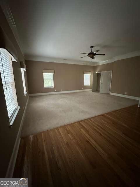 8010 Scudder Way, Ball Ground, GA 30107 - unfurnished living room with ornamental molding, plenty of natural light, a ceiling fan, and baseboards
